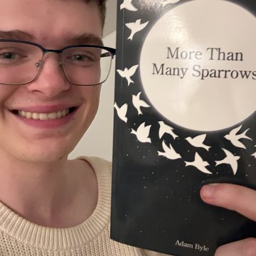 Adam holding a book he wrote