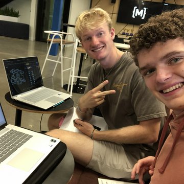 Adam and a friend at a hackathon